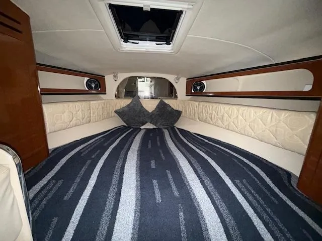 Slide: The Image of 2003 Sea Ray 280 Sundancer cabin interior with striped carpet and cushions. - 12