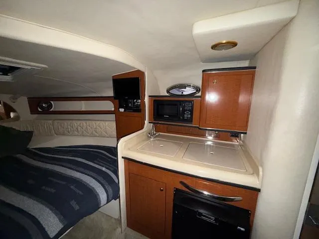 Slide: The Image of Interior of 2003 Sea Ray 280 Sundancer with kitchenette and cozy sleeping area. - 15