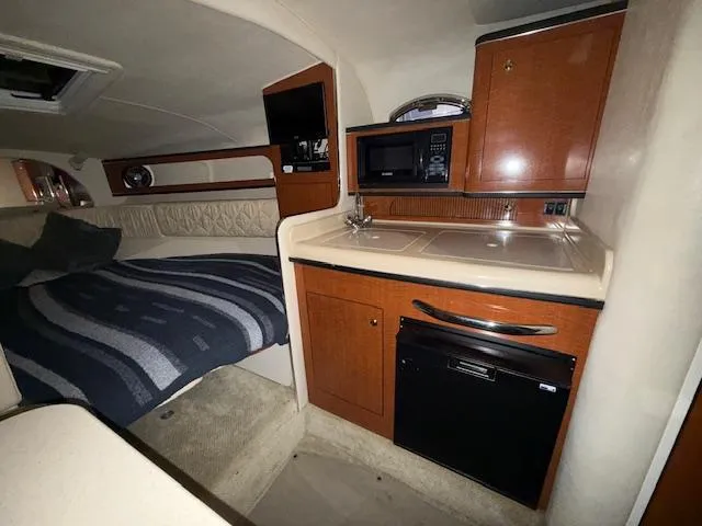 Slide: The Image of Interior of 2003 Sea Ray 280 Sundancer with kitchenette and bed. - 16