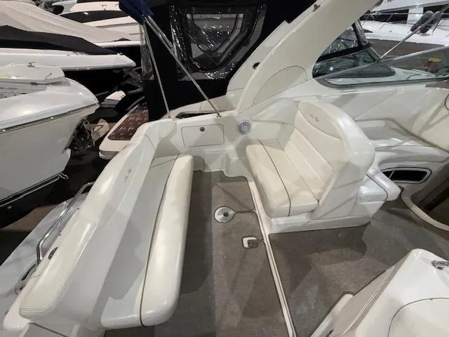 Slide: The Image of 2003 Sea Ray 280 Sundancer boat interior with white seating and carpeted floor. - 5