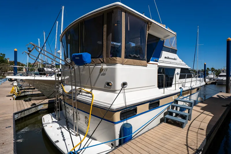 Slide: The Image of 1988 Carver 42 Aft Cabin Motoryacht docked at marina under clear blue sky. - 13