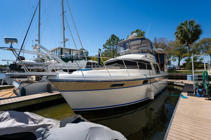 Slide: The Image of 1988 Carver 42 Aft Cabin Motoryacht docked at marina under clear blue sky. - 8