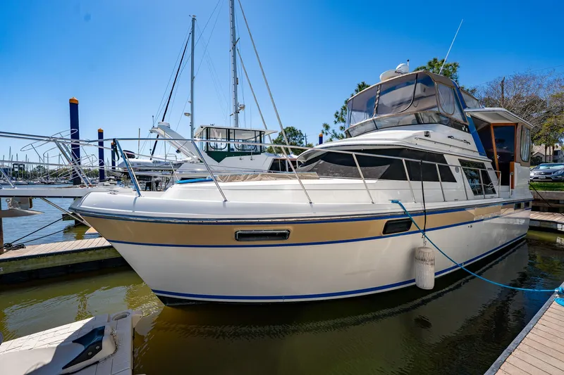 Slide: The Image of 1988 Carver 42 Aft Cabin Motoryacht docked at marina under clear blue sky. - 10