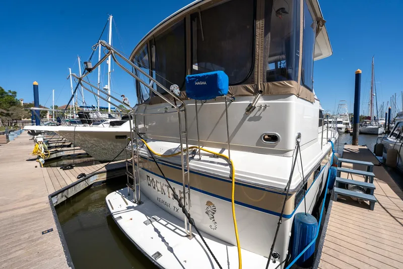 Slide: The Image of 1988 Carver 42 Aft Cabin Motoryacht docked at marina under clear blue sky. - 14