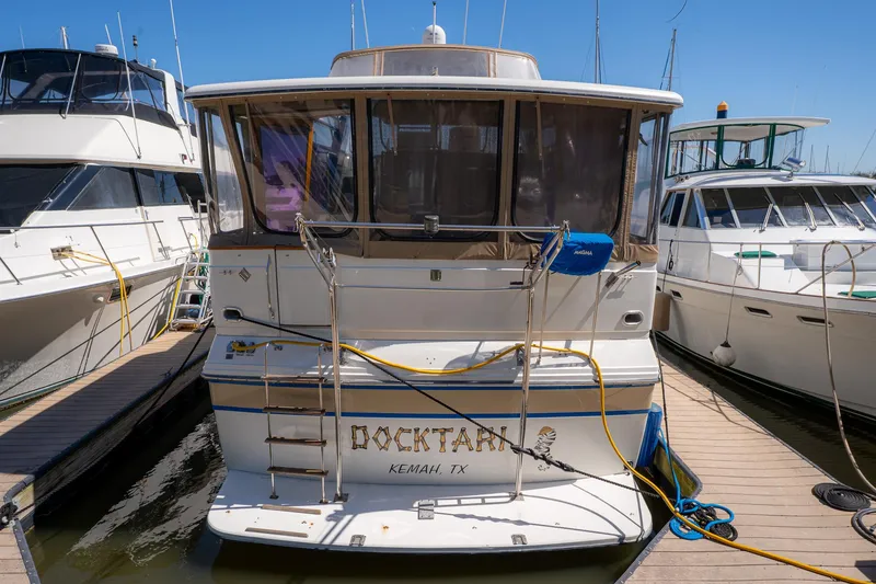 Slide: The Image of 1988 Carver 42 Aft Cabin Motoryacht docked at marina, rear view. - 2
