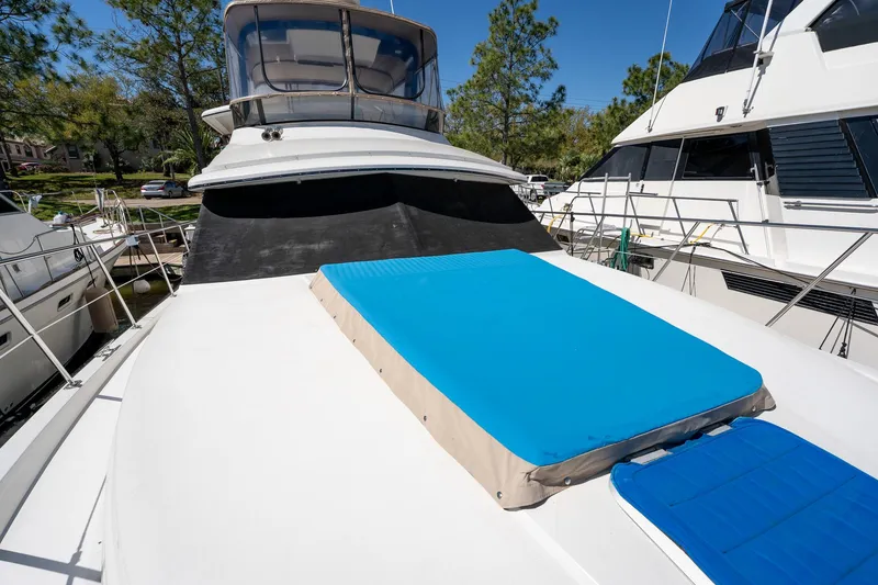 Slide: The Image of 1988 Carver 42 Aft Cabin Motoryacht with blue sun pad on deck, docked in marina. - 22