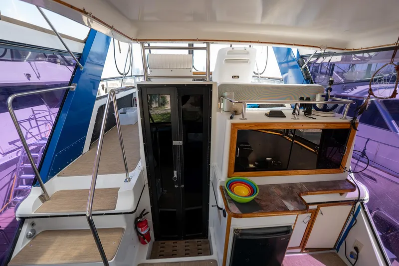 Slide: The Image of 1988 Carver 42 Aft Cabin Motoryacht interior with kitchenette and stairs, featuring vibrant accents. - 34