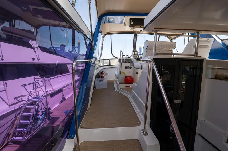 Slide: The Image of 1988 Carver 42 Aft Cabin Motoryacht interior with helm, seating, and purple-tinted windows. - 37