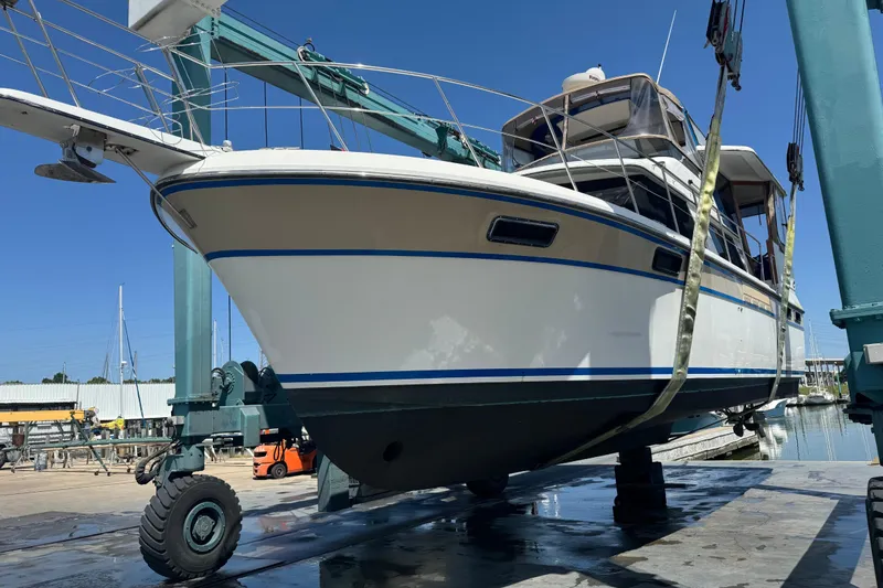 Slide: The Image of 1988 Carver 42 Aft Cabin Motor Yacht on lift, marina background, clear sky. - 114