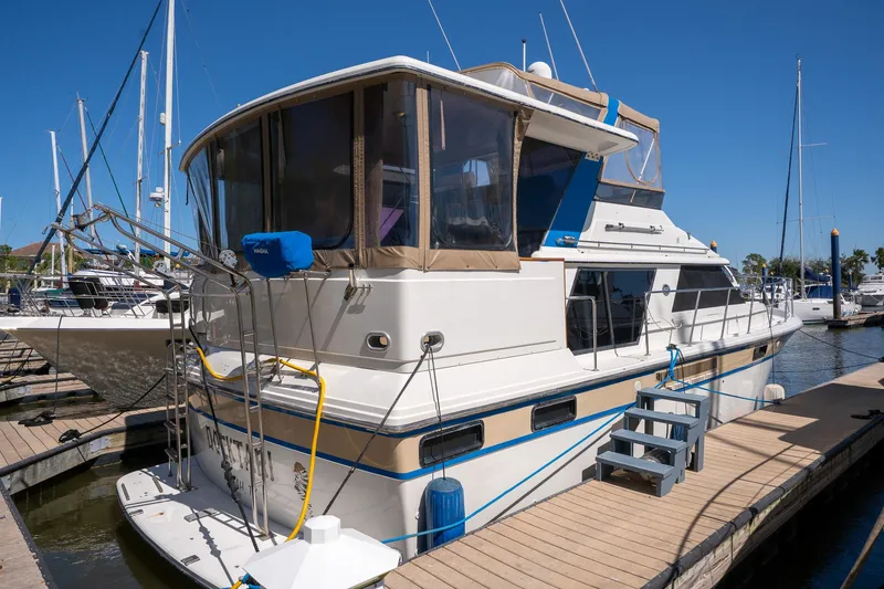 Slide: The Image of 1988 Carver 42 Aft Cabin Motoryacht docked at marina under clear blue sky. - 4