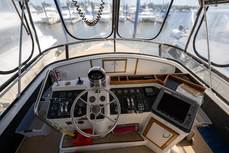 Slide: The Image of 1988 Carver 42 Aft Cabin Motoryacht helm with steering wheel and navigation equipment. - 40