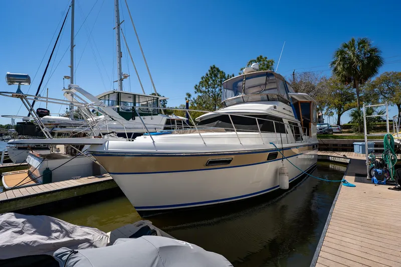 Slide: The Image of 1988 Carver 42 Aft Cabin Motoryacht docked at marina under clear blue sky. - 9