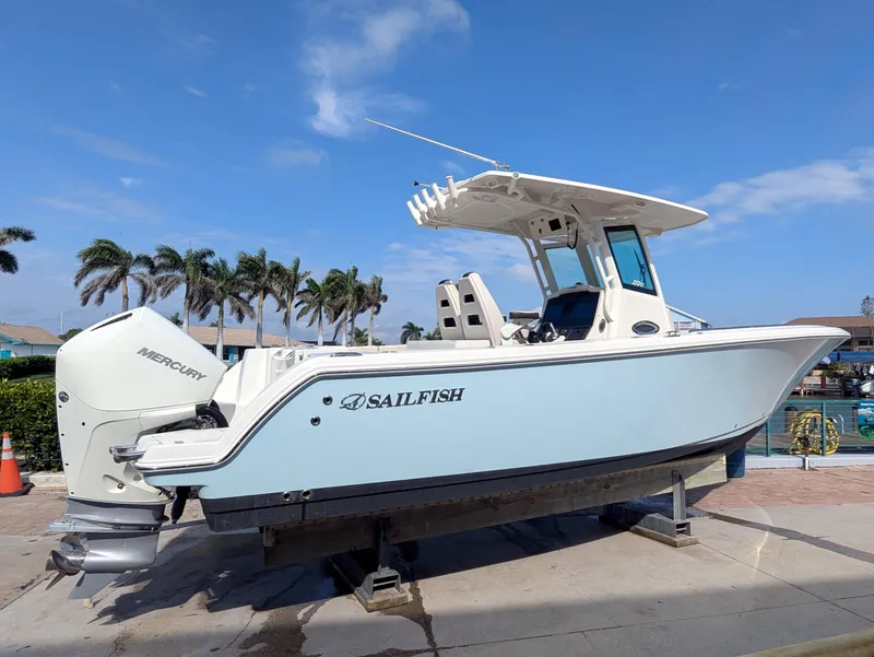 Slide: The Image of 2023 Sailfish 272 CC boat with Mercury engine, docked under clear blue sky. - 0