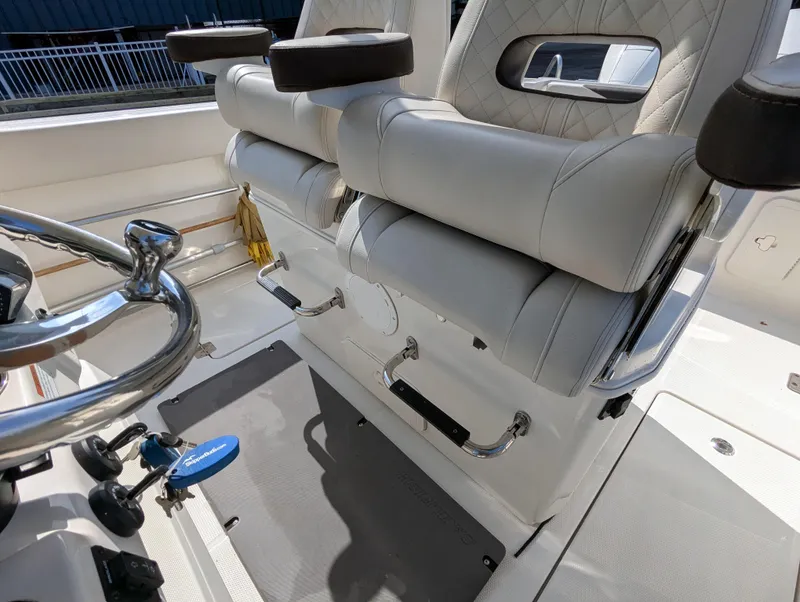 Slide: The Image of 2023 Sailfish 272 CC boat interior with plush seating and modern steering wheel. - 10