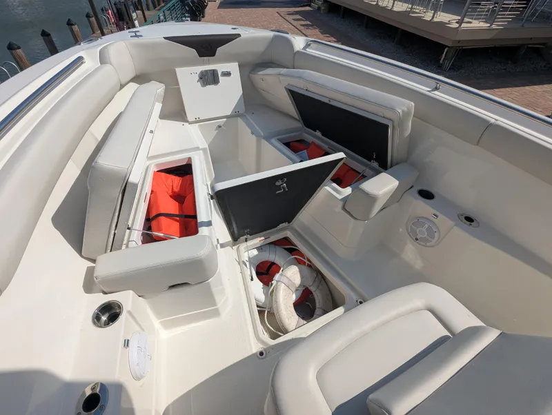 Slide: The Image of 2023 Sailfish 272 CC boat interior with open storage compartments and life jackets. - 18