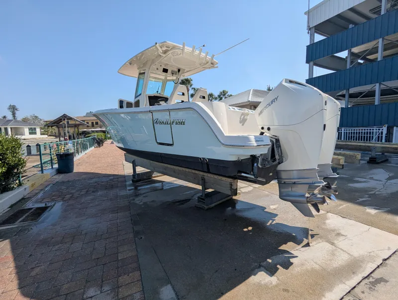 Slide: The Image of 2023 Sailfish 272 CC boat on a dock, featuring dual outboard engines. - 2