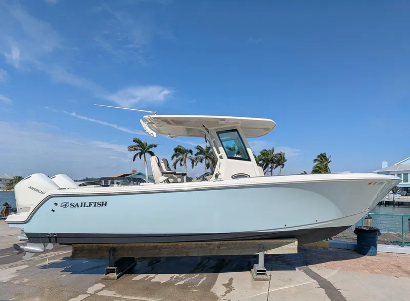 Slide: The Image of 2023 Sailfish 272 CC boat on display at a marina with palm trees. - 3