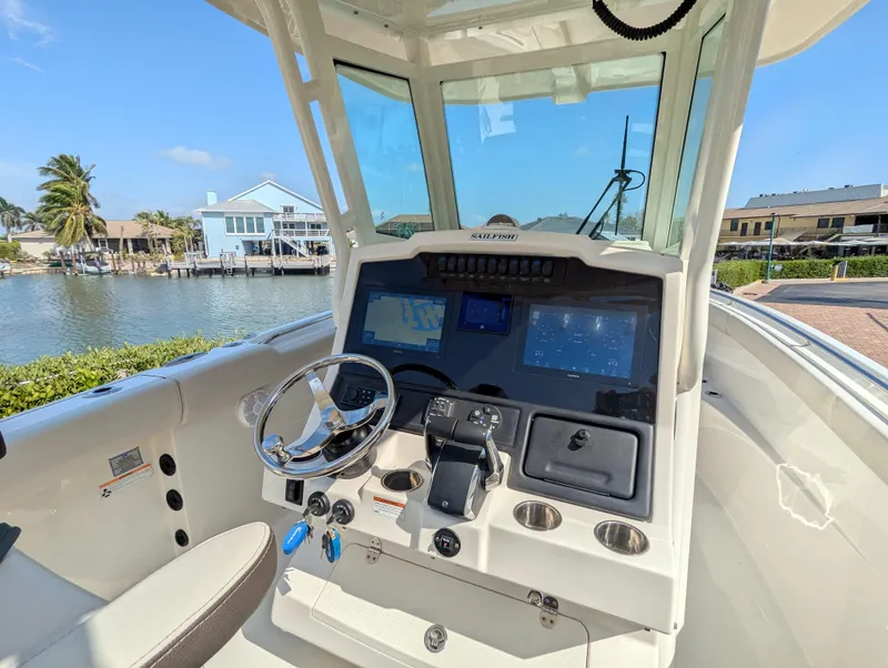 Slide: The Image of 2023 Sailfish 272 CC boat cockpit with modern navigation system and waterfront view. - 4