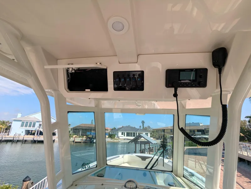 Slide: The Image of Interior view of 2023 Sailfish 272 CC boat with control panel and waterfront background. - 7