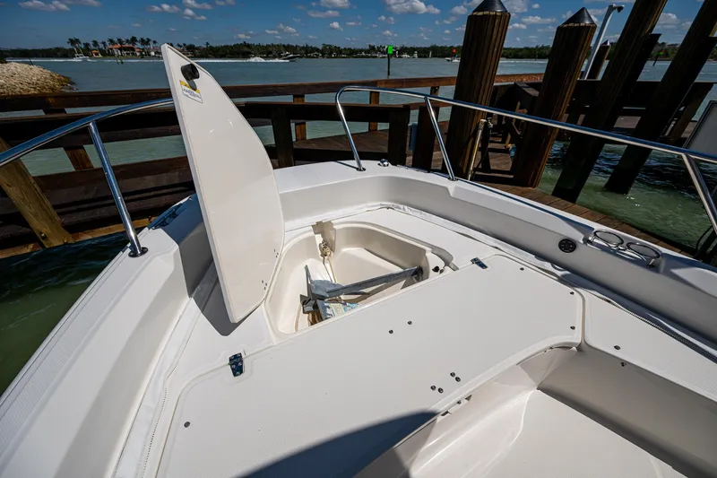 Slide: The Image of 2020 Boston Whaler 210 Dauntless boat with open storage compartment, docked by wooden pier. - 12