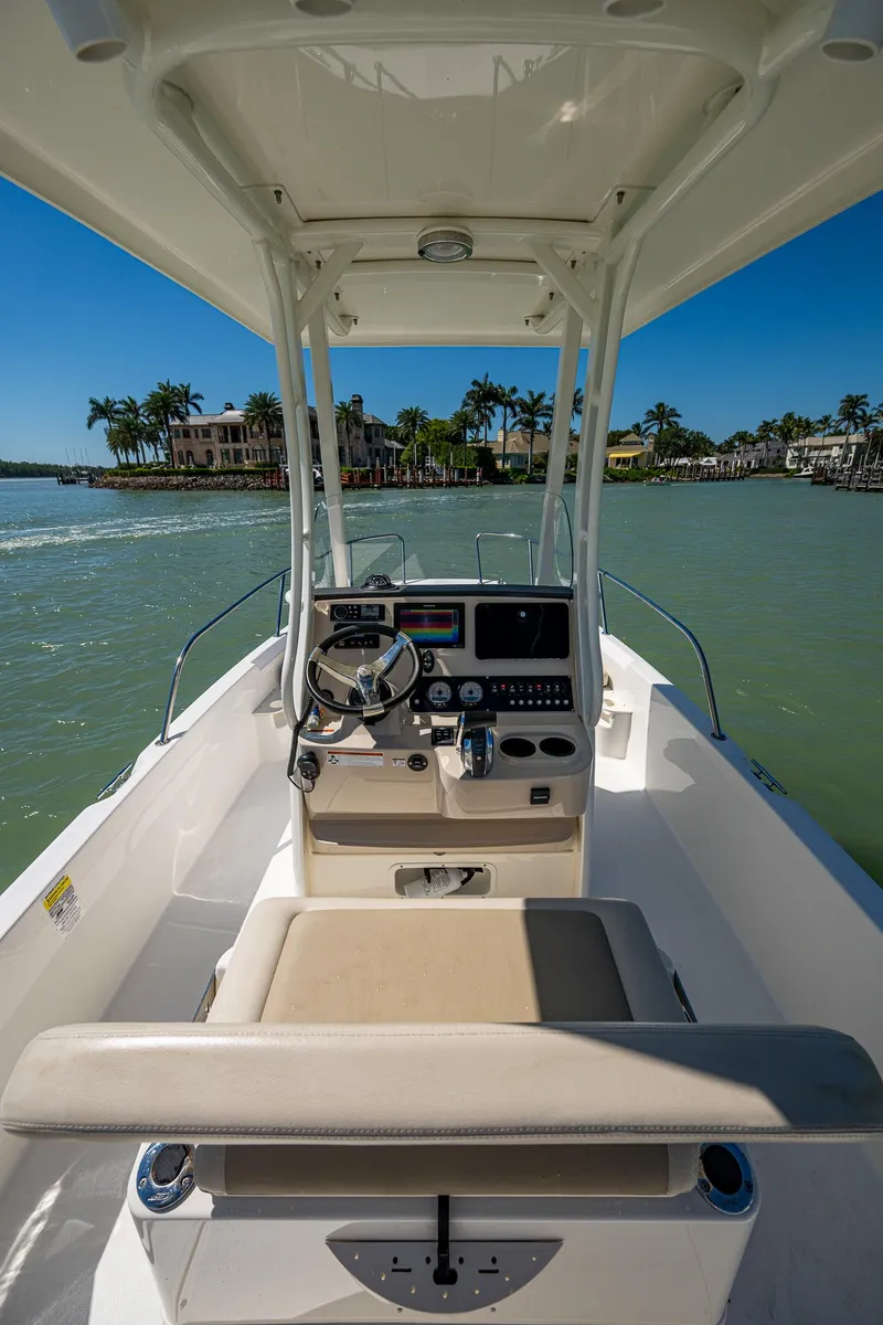 Slide: The Image of 2020 Boston Whaler 210 Dauntless boat interior with steering console, on calm water. - 5