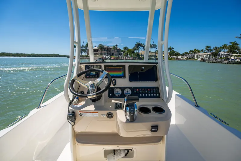 Slide: The Image of Boston Whaler 210 Dauntless 2020 boat console with steering wheel and controls on water. - 6