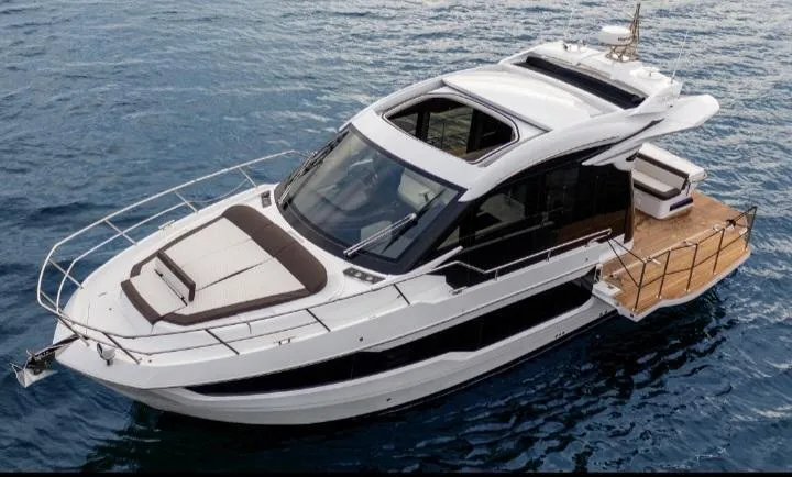 Slide: The Image of 2022 Galeon 410 HTC yacht on calm blue water, showcasing sleek design and luxury features. - 0