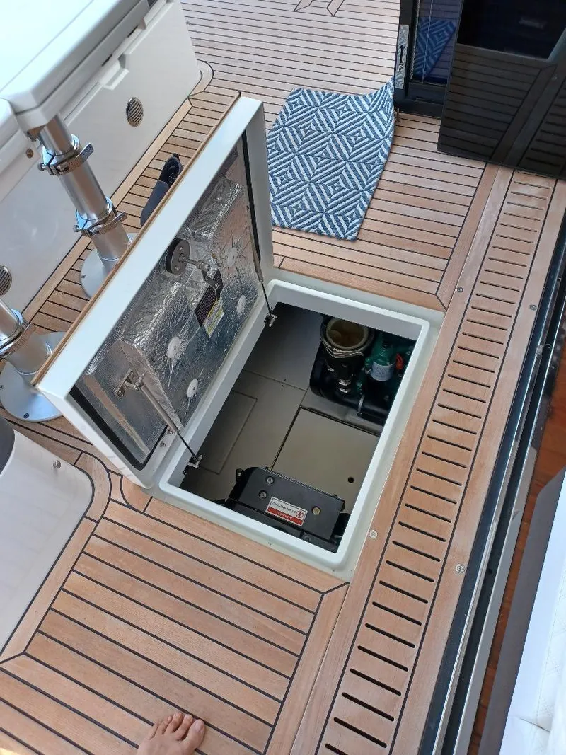 Slide: The Image of Galeon 410 HTC 2022 yacht deck with open hatch revealing storage compartment. - 12