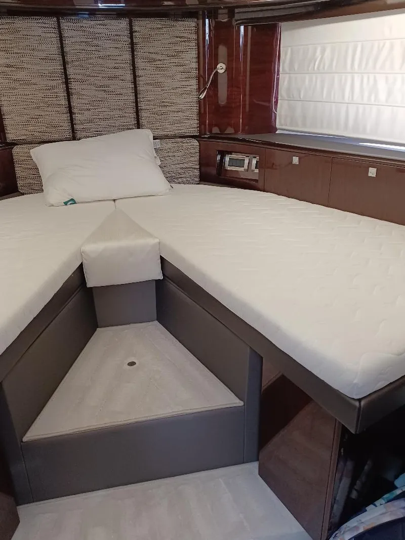 Slide: The Image of Interior cabin of 2022 Galeon 410 HTC yacht with modern bedding and wood accents. - 22