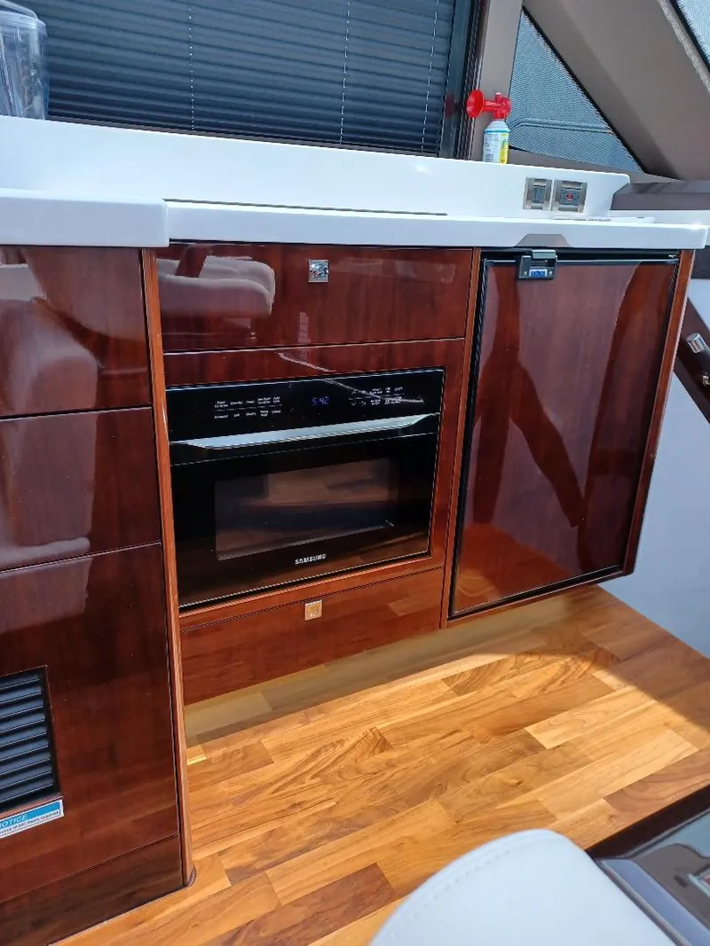 Slide: The Image of 2022 Galeon 410 HTC yacht interior with wood cabinetry and modern appliances. - 30