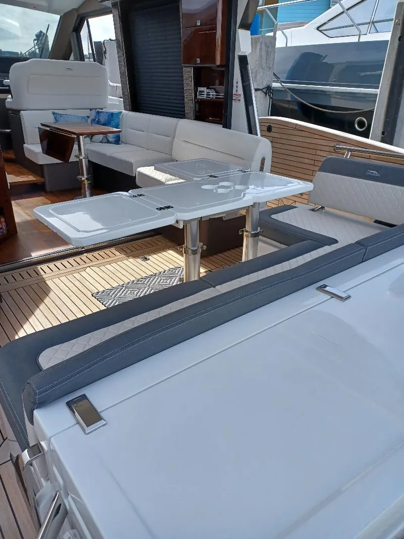 Slide: The Image of 2022 Galeon 410 HTC yacht interior with modern seating and dining area. - 32