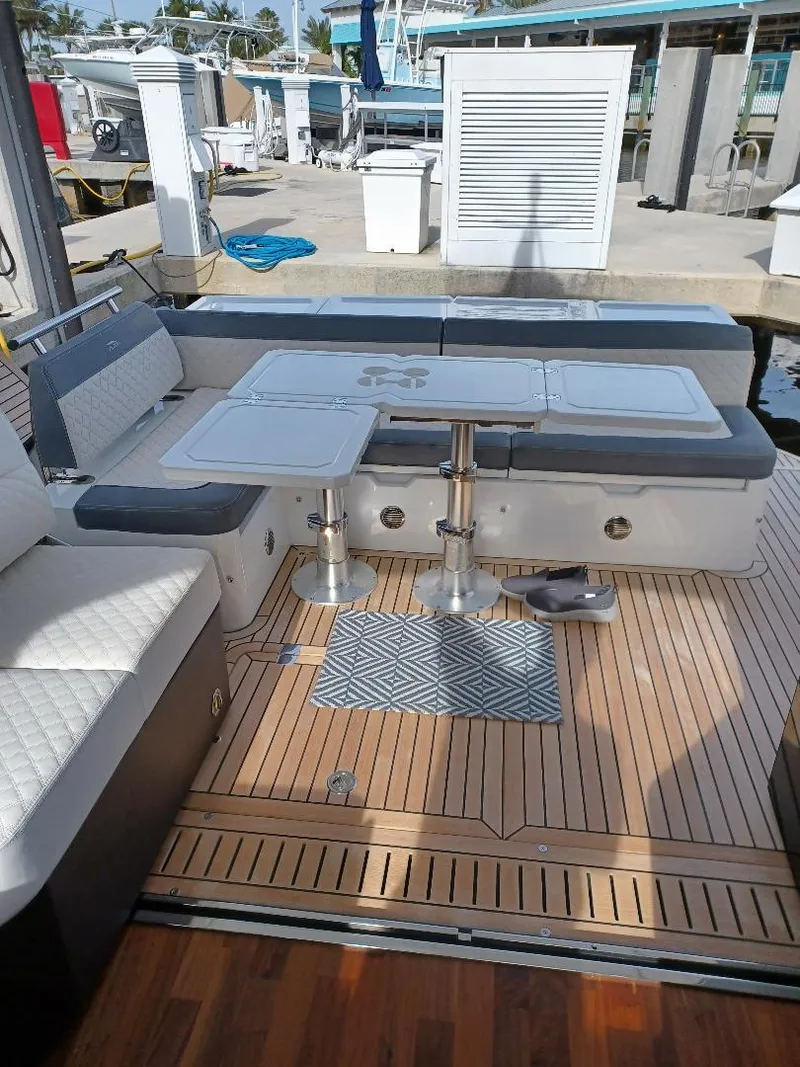 Slide: The Image of 2022 Galeon 410 HTC yacht deck with seating and table at marina. - 34