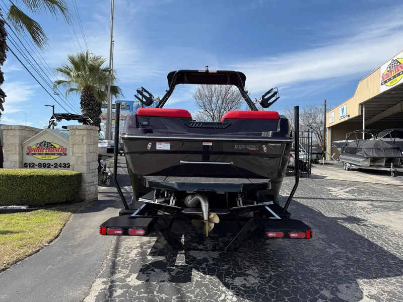 Slide: The Image of 2025 Moomba Tykon boat, rear view, parked outdoors at a dealership. - 11