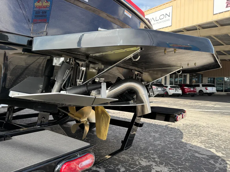 Slide: The Image of 2025 Moomba Tykon boat stern with propeller and exhaust system, parked outdoors. - 12