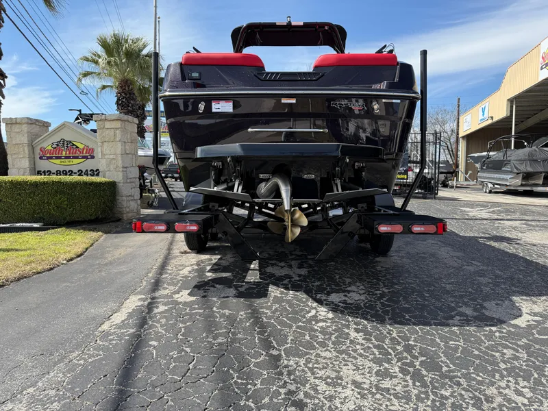 Slide: The Image of 2025 Moomba Tykon boat rear view at dealership, showcasing propeller and trailer. - 15