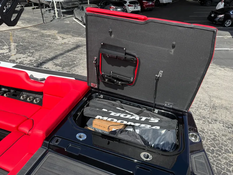 Slide: The Image of 2025 Moomba Tykon boat storage compartment with red seating and accessories. - 24