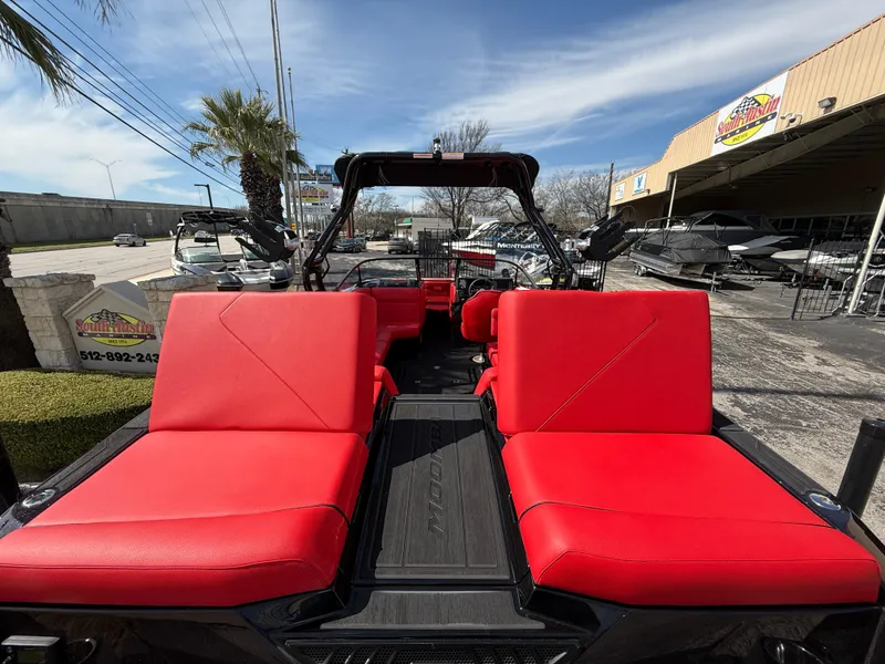 Slide: The Image of 2025 Moomba Tykon boat with vibrant red seating, displayed outdoors. - 26