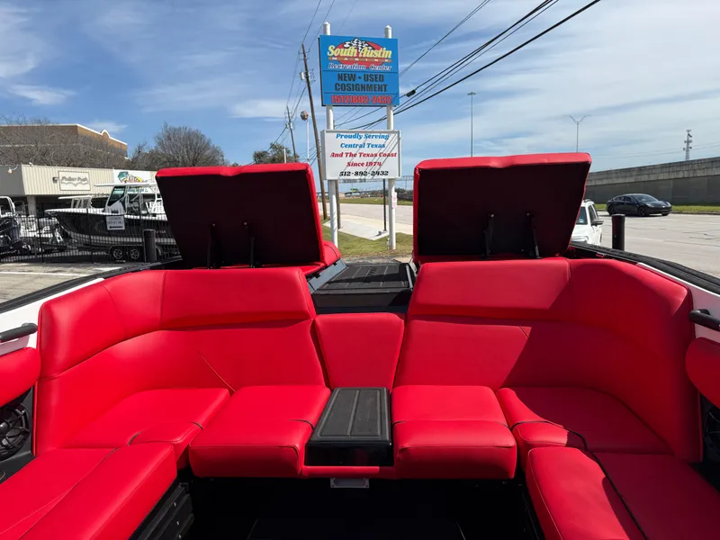 Slide: The Image of 2025 Moomba Tykon boat with vibrant red seating and open storage compartments. - 32