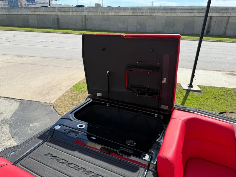 Slide: The Image of 2025 Moomba Tykon boat interior with open storage compartment and red seating. - 36