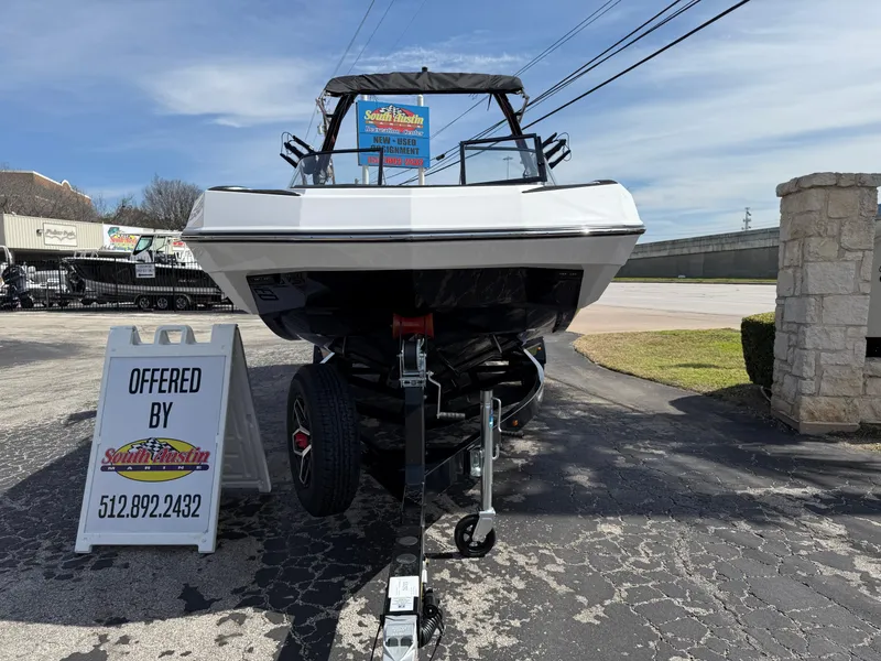 Slide: The Image of 2025 Moomba Tykon boat on trailer, displayed outdoors with dealership sign. - 4
