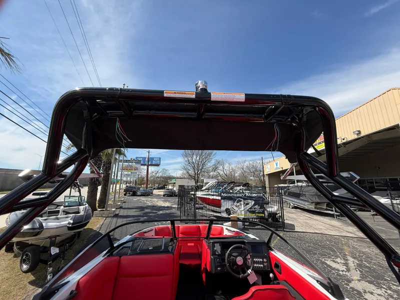 Slide: The Image of 2025 Moomba Tykon boat with red interior and black tower, parked outdoors. - 42