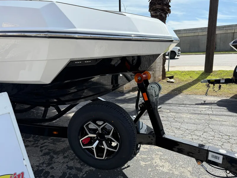 Slide: The Image of 2025 Moomba Tykon boat on trailer, parked outdoors on a sunny day. - 5