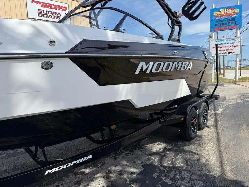 Slide: The Image of 2025 Moomba Tykon boat on trailer, black and white design, parked outdoors. - 8