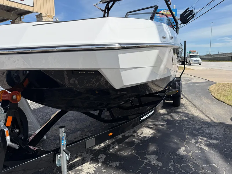 Slide: The Image of 2025 Moomba Tykon boat on trailer, white hull, parked outdoors. - 9