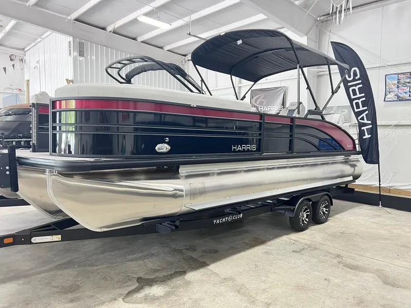The Image of 2024 Harris Sunliner 250 pontoon boat in showroom, featuring sleek design and modern amenities. - 0