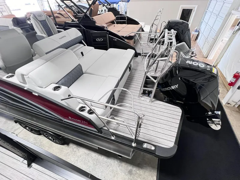 Slide: The Image of 2024 Harris Sunliner 250 pontoon boat with spacious seating and Mercury outboard motor. - 10
