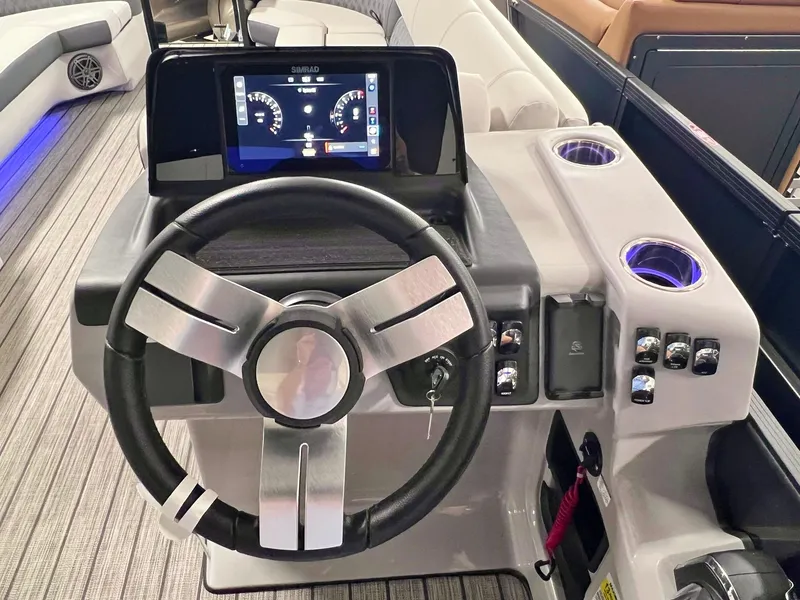 Slide: The Image of 2024 Harris Sunliner 250 boat dashboard with steering wheel and digital display. - 13