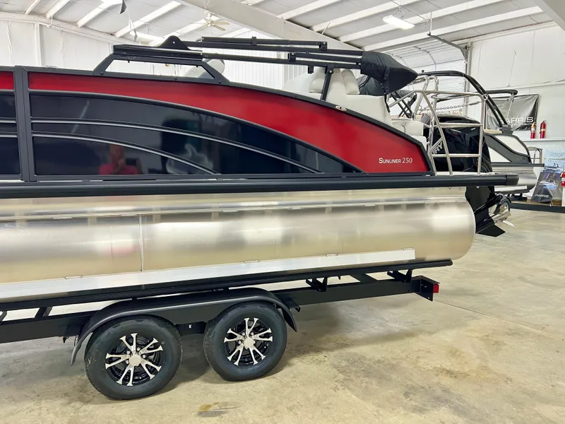 Slide: The Image of 2024 Harris Sunliner 250 pontoon boat on trailer in indoor storage facility. - 2
