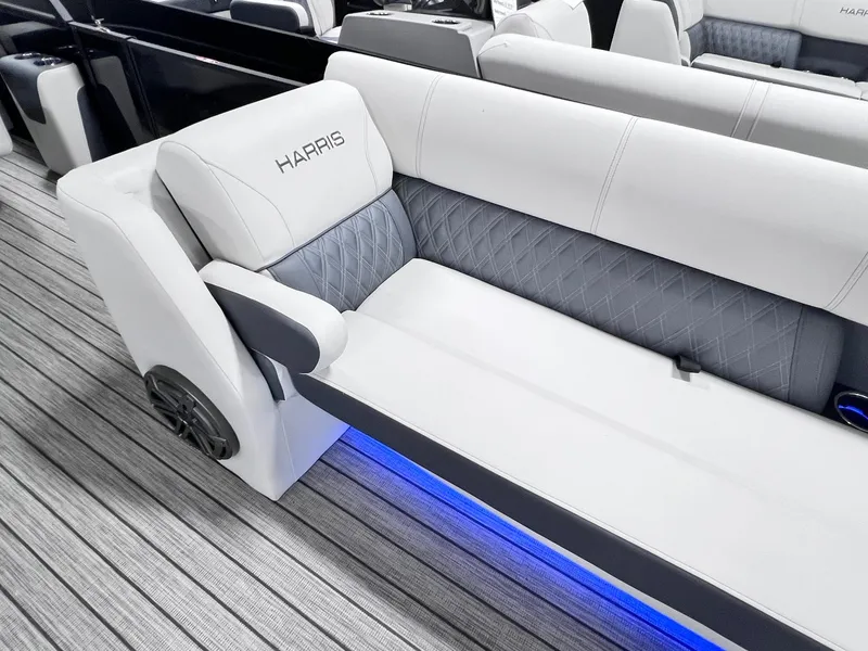 Slide: The Image of 2024 Harris Sunliner 250 boat interior with sleek seating and ambient blue lighting. - 26