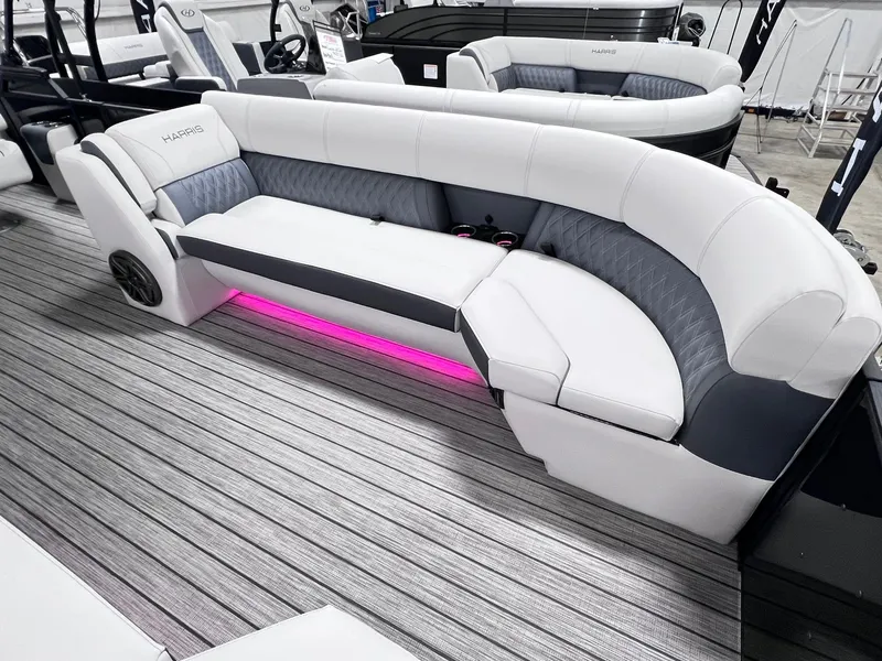 Slide: The Image of 2024 Harris Sunliner 250 boat interior with plush seating and ambient pink lighting. - 27